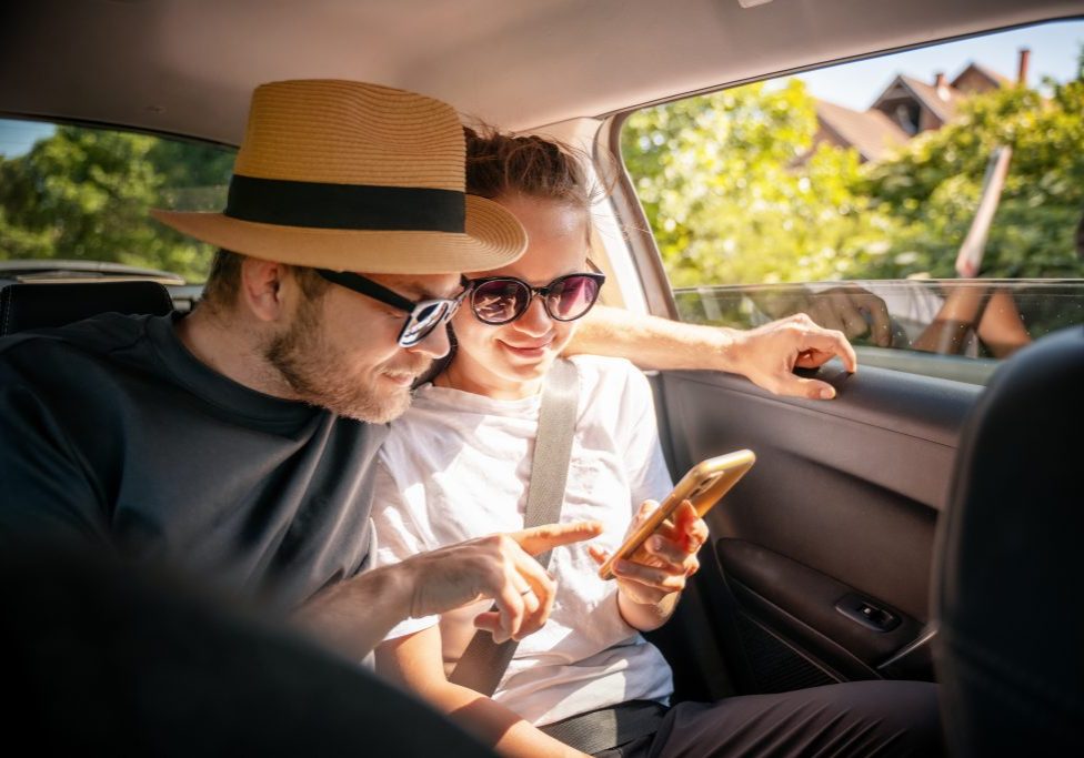 Young,Cheerful,Happy,Couple,Of,Travelers,Sitting,In,Car,Looking